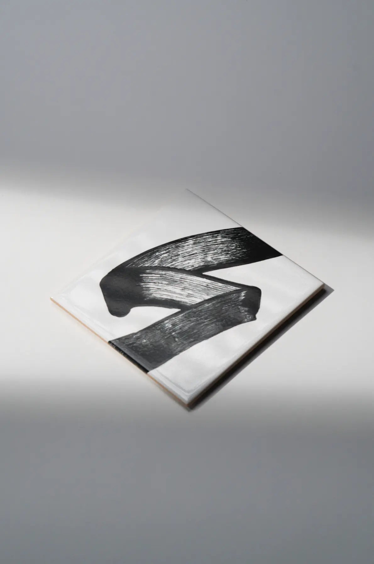 Single tile from JonOne First Series by Clay featuring expressive black brushstroke art – available exclusively at Clay