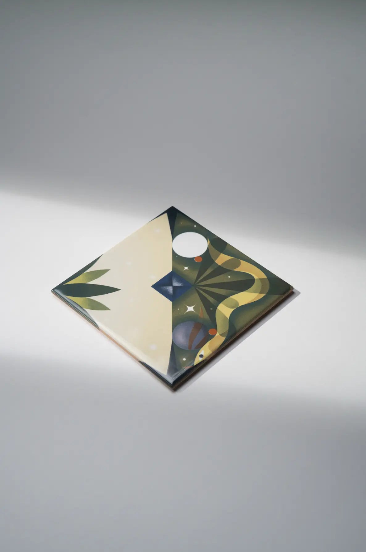 Angled corner view of Pattern Kruella D’Enfer ceramic tile by Clay with whimsical green and cream shapes – on sale at Clay