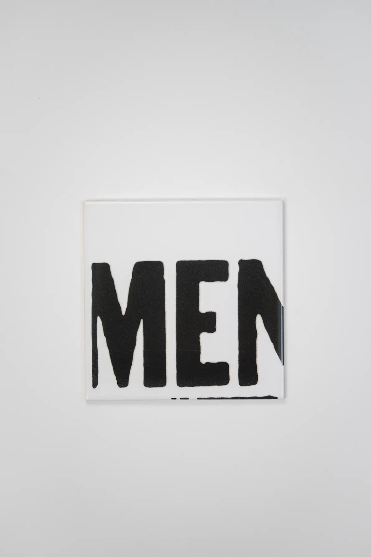 Pattern VHILS ceramic tile by Clay showing black MEN typography on white background – shop now at Clay